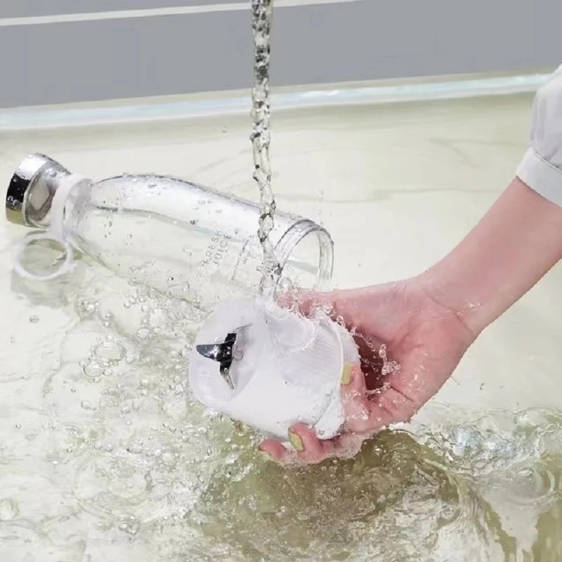The Fourfold Whirl 350's cup being rinsed under a running faucet, its blades inside